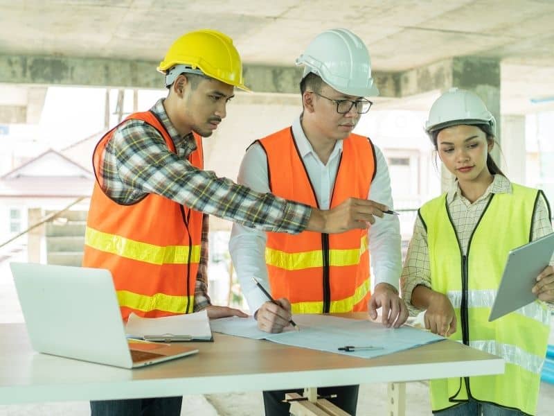 Construction professionals reviewing plans during a commercial property redevelopment project.